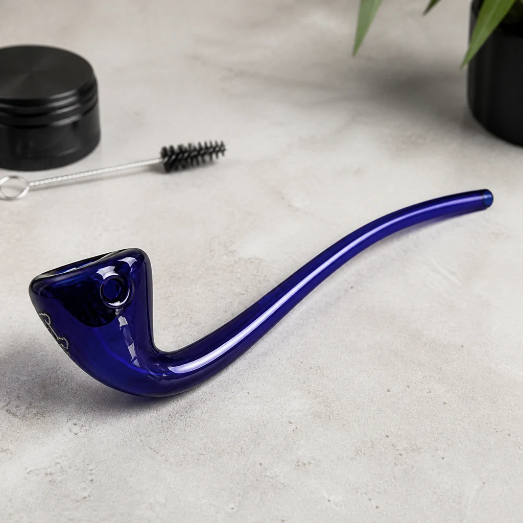 Pipa Gandalf azul de tubo largo y curvado sobre una superficie gris, con un cepillo y un recipiente negro al fondo.