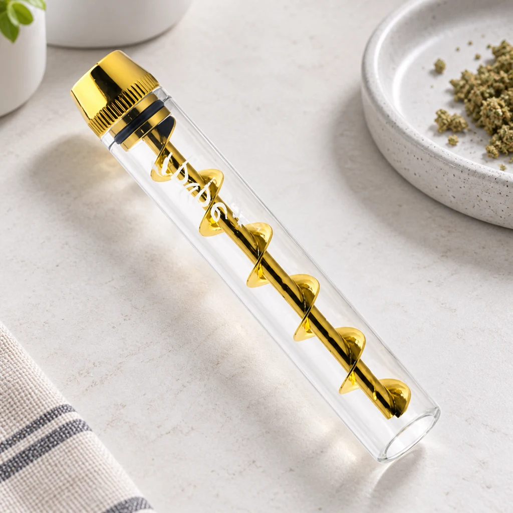 Pipa Original Twisty Blunt con tubo transparente y espiral dorada, colocada en diagonal junto a un plato con material vegetal.