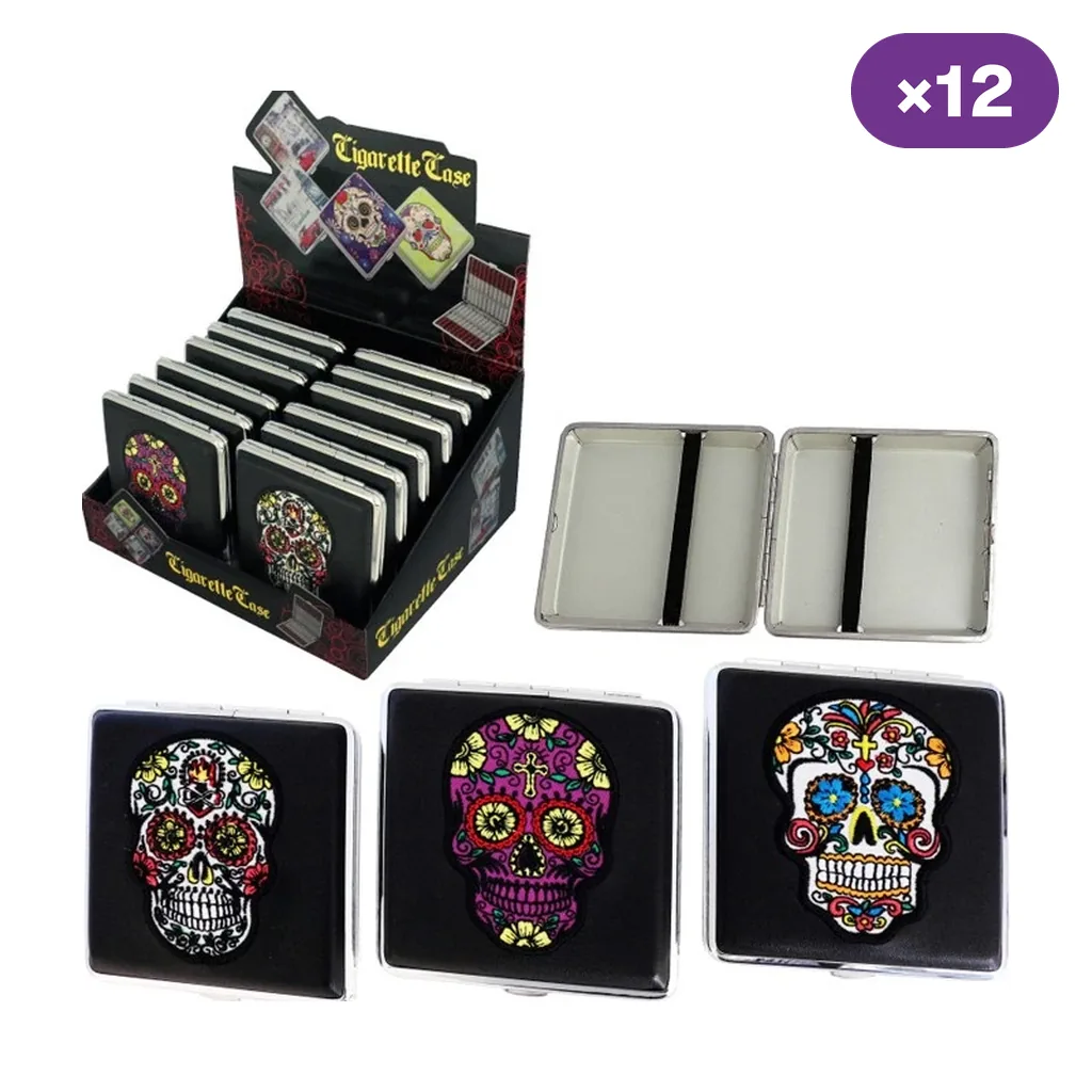 Selección de pitilleras negras con calaveras de colores, un modelo abierto con sujeciones interiores y un expositor marcado con 12 unidades.