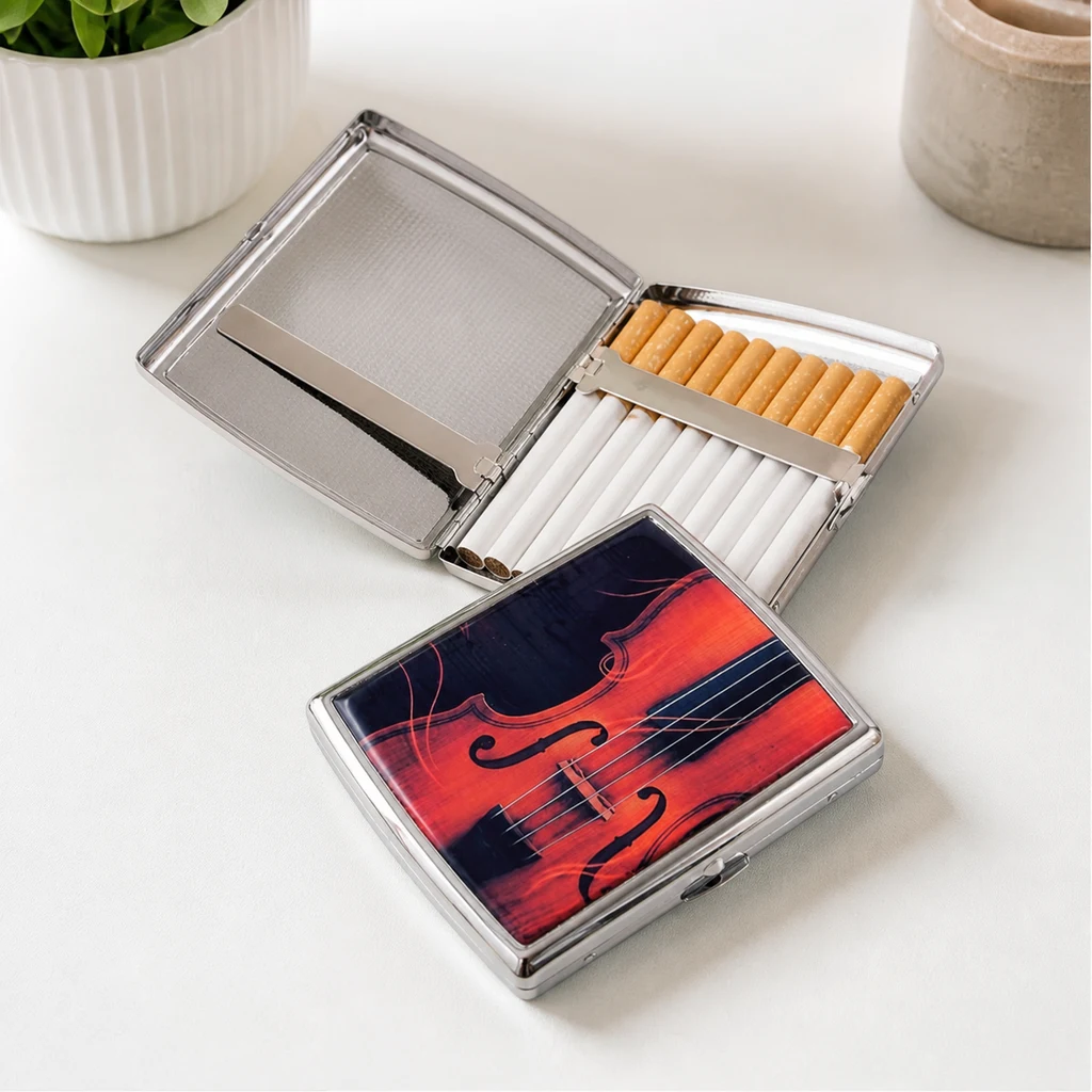Pitillera abierta con cigarrillos sujetos por una banda y otra cerrada con un diseño de violín rojo y negro sobre la tapa.