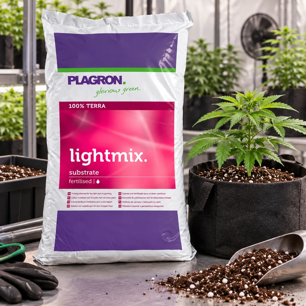 Saco de Plagron Lightmix junto a una planta en maceta textil, con una pala y sustrato esparcido sobre la mesa en una escena de cultivo interior.