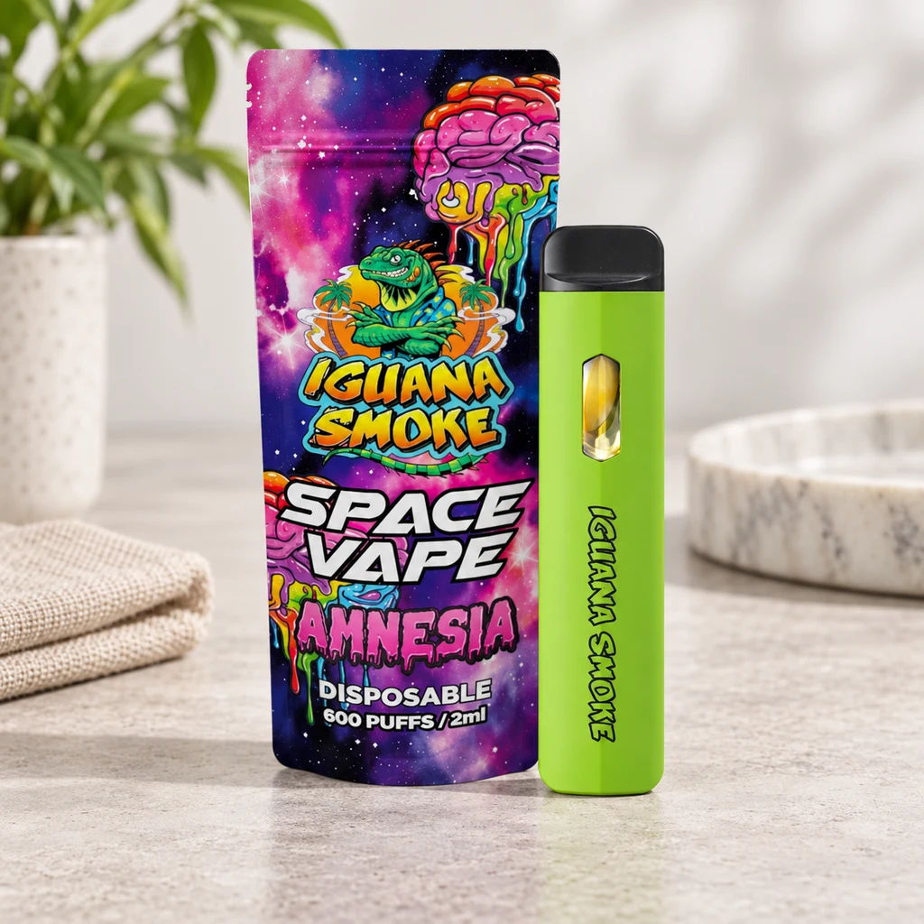 Space Vape Amnesia de Iguana Smoke verde con boquilla negra, junto a un envase de diseño espacial que indica 600 caladas y 2 ml.