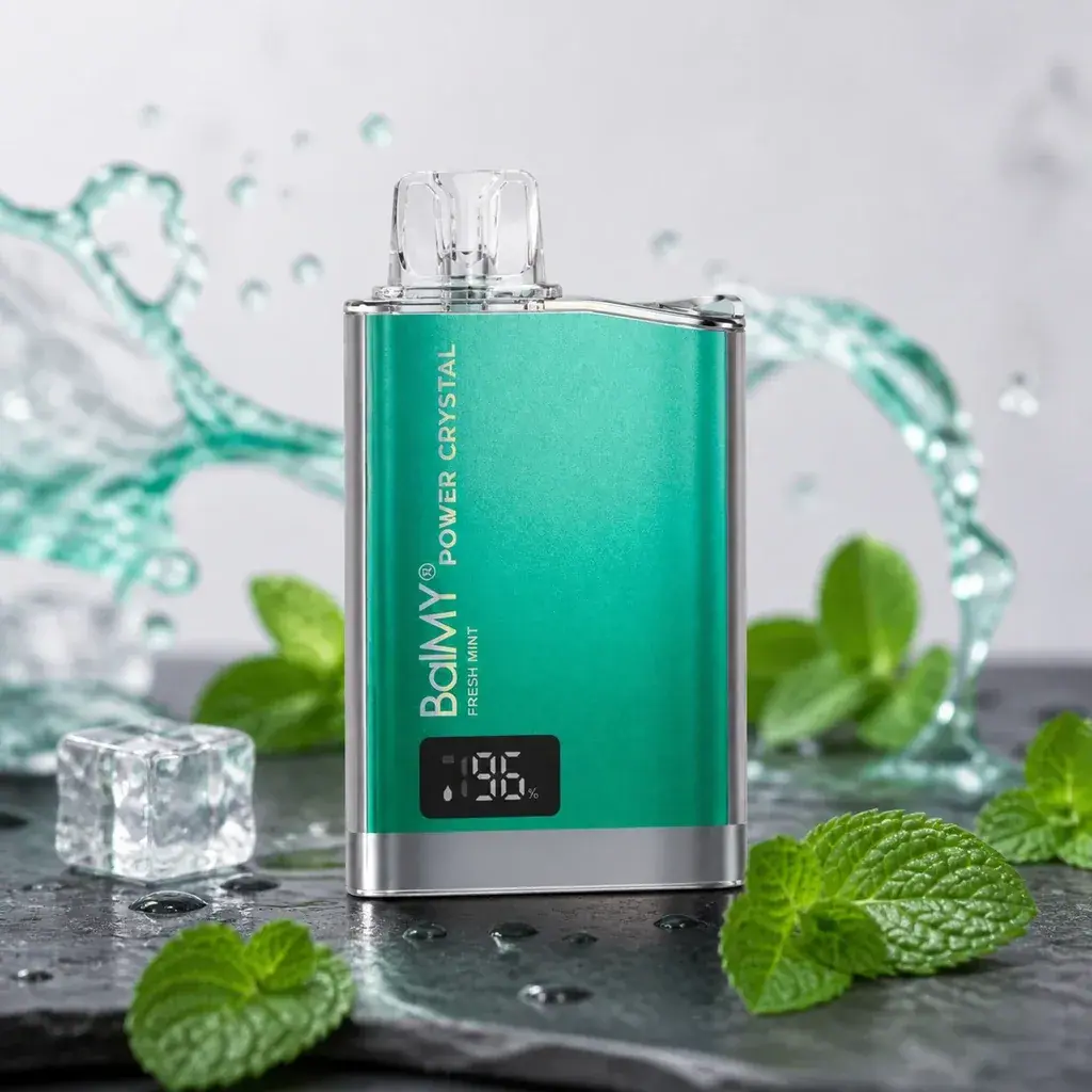Vaper Balmy Power Crystal Fresh Mint verde con boquilla transparente y pantalla, rodeado de hojas de menta, hielo y salpicaduras.