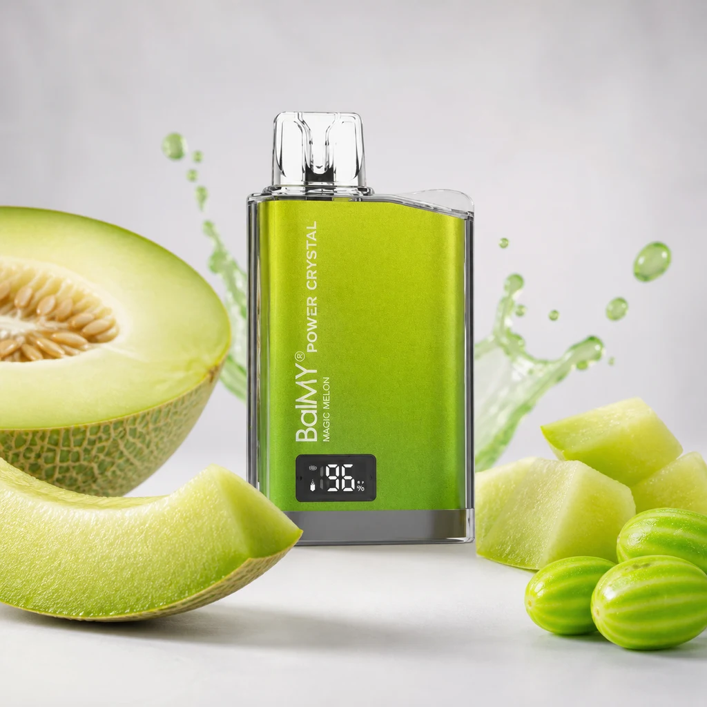 Vaper Balmy Power Crystal Magic Melon verde, con boquilla transparente y pantalla, entre trozos de melón y salpicaduras verdes.