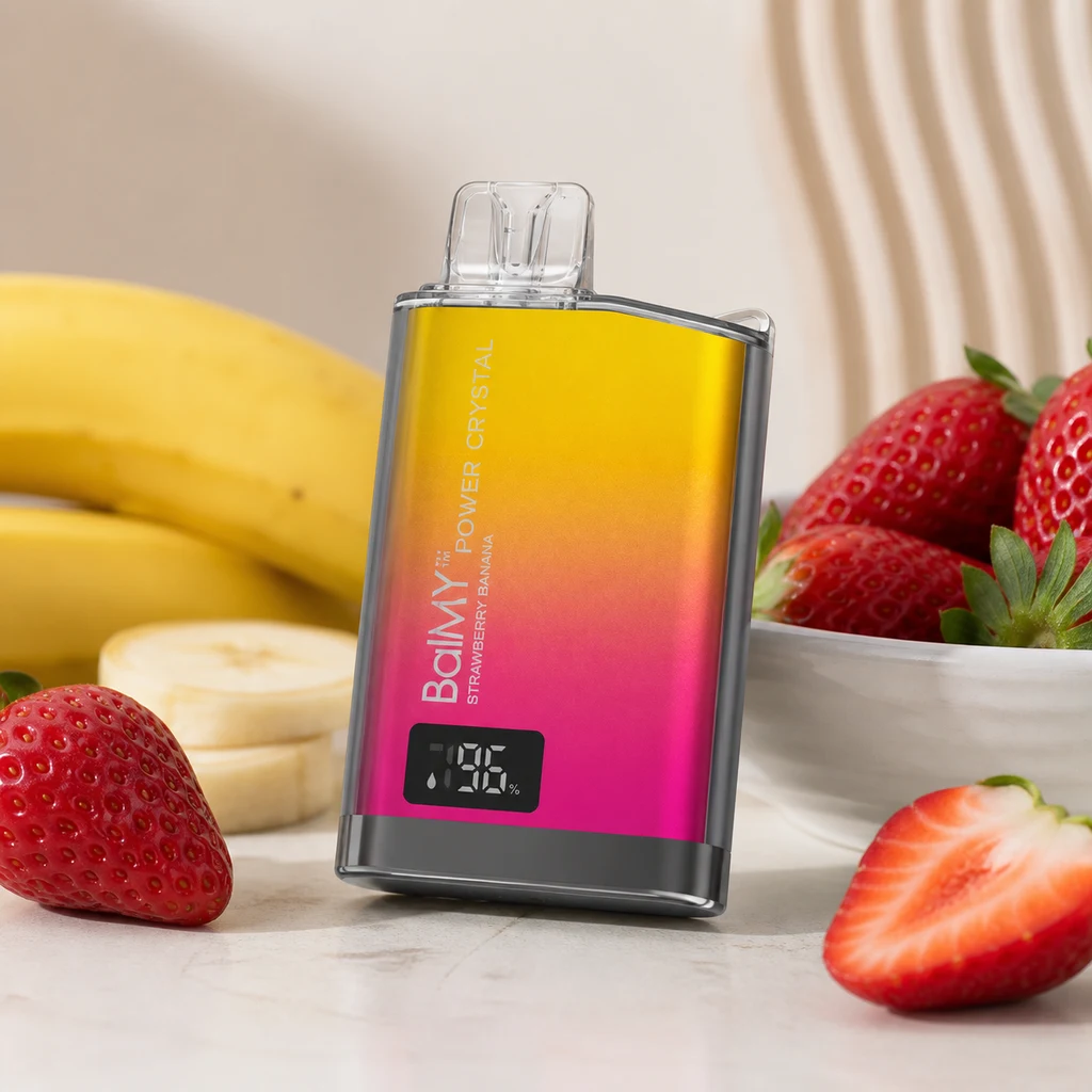 Vaper Balmy Power Crystal Strawberry Banana con degradado amarillo y rosa, boquilla transparente y pantalla, rodeado de fresas y plátanos.