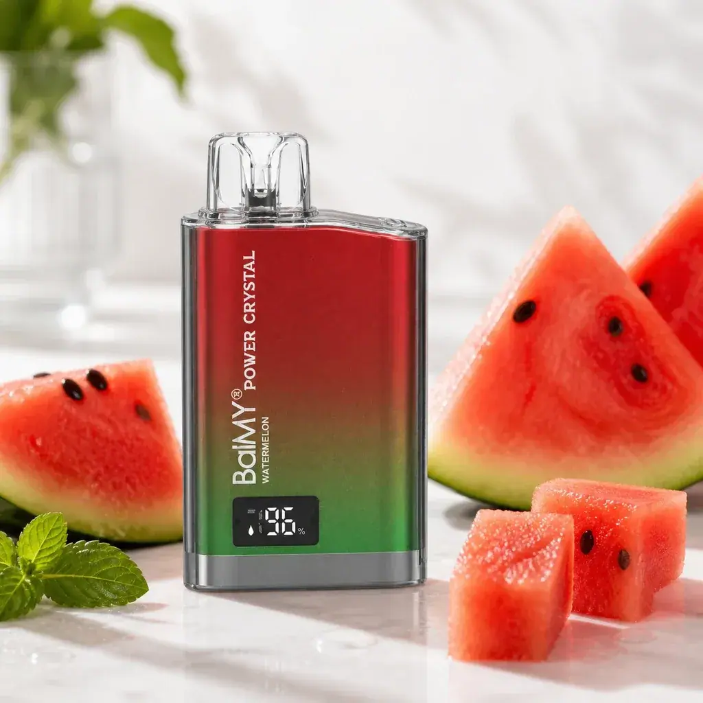 Vaper Balmy Power Crystal Sandía con cuerpo rojo y verde, boquilla transparente y pantalla, rodeado de trozos de sandía.