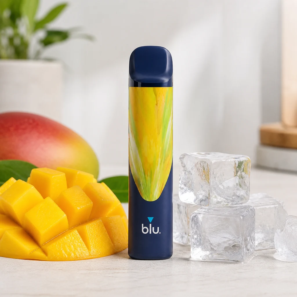 Pod Blu Bar Mango Ice azul oscuro con diseño amarillo y verde, junto a mango cortado y cubitos de hielo sobre una mesa clara.