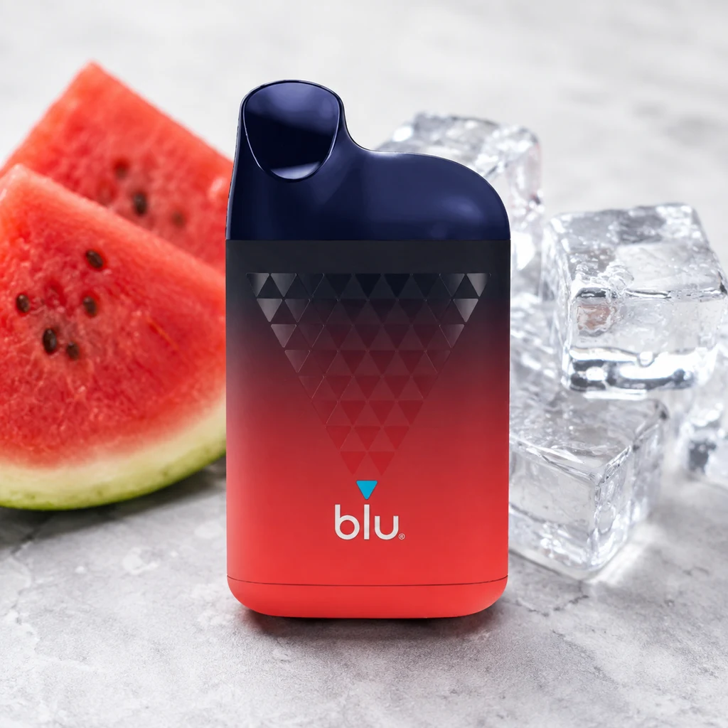Blu Box Watermelon Ice con cuerpo degradado de azul oscuro a rojo y dibujo de triángulos, junto a rodajas de sandía y cubitos de hielo.
