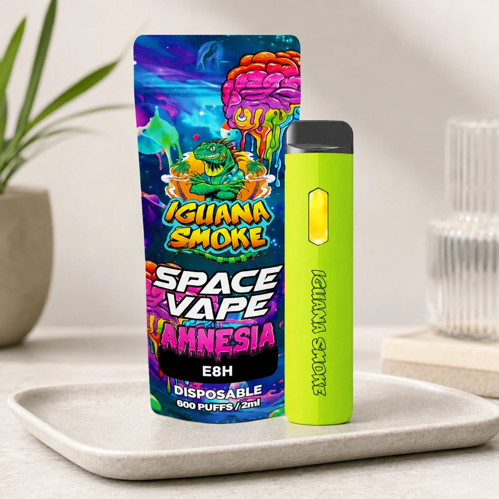 Pod Space Vape Amnesia verde lima con boquilla negra, junto a un envase multicolor con los textos Iguana Smoke y E8H, sobre una bandeja.