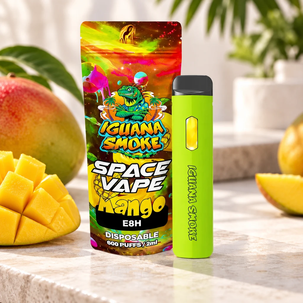Vaper verde Space Vape Mango E8H junto a un envase multicolor de Iguana Smoke, rodeado de mangos enteros y cortados.