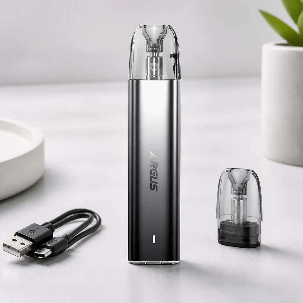 Dispositivo Argus gris oscuro con cartucho transparente, junto a un cartucho separado y un cable USB sobre una mesa clara. Dispositivo Argus gris oscuro con cartucho transparente, junto a un cartucho separado y un cable USB sobre una mesa clara.