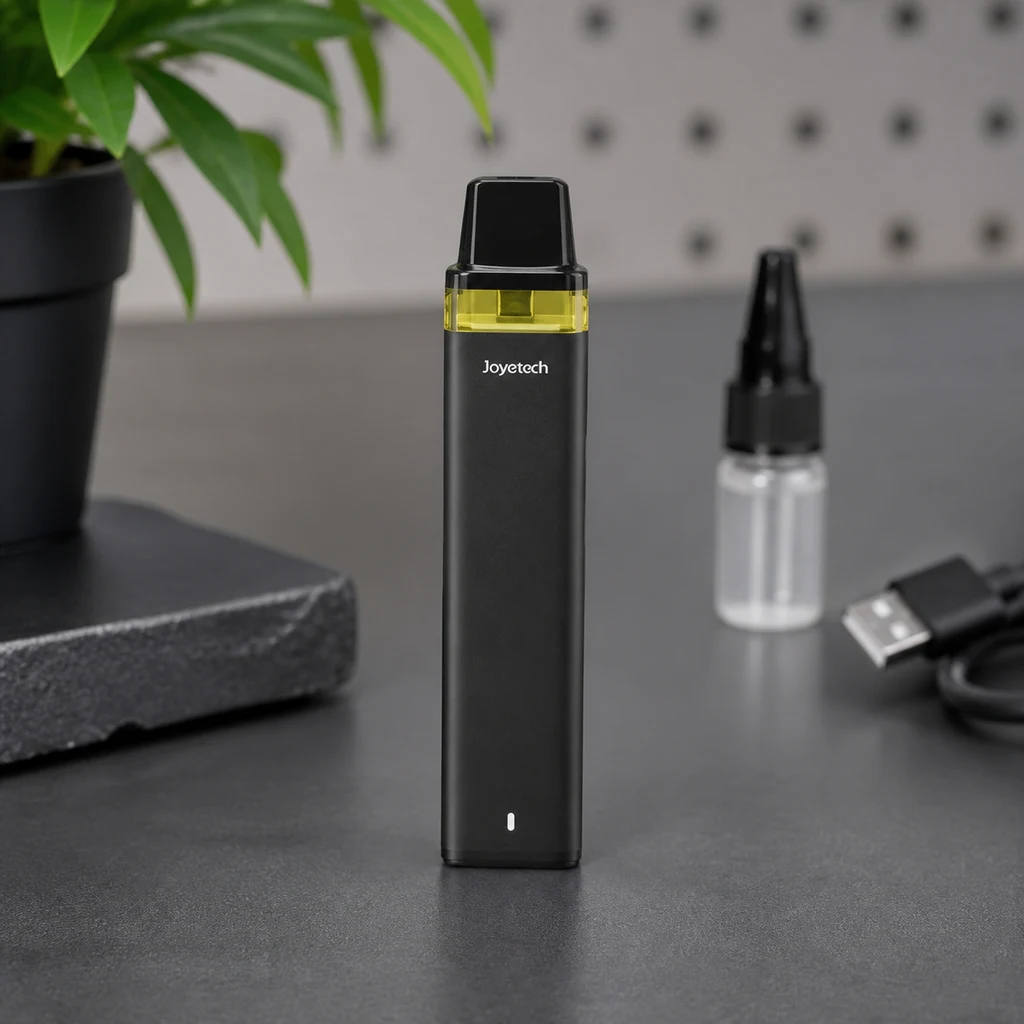 Vaper Joyetech WideWick negro en posición vertical, con boquilla negra y depósito translúcido amarillo; detrás hay un frasco y un cable USB.