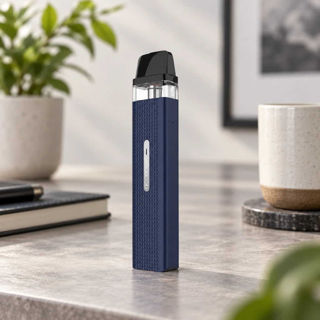 Vaporesso Xros Mini azul con cuerpo texturizado, depósito transparente y boquilla negra, de pie sobre una mesa.