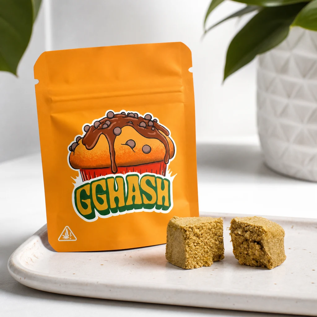 Bolsa naranja con el texto GGHASH y un muffin ilustrado, junto a porciones de hash dorado sobre una bandeja clara.
