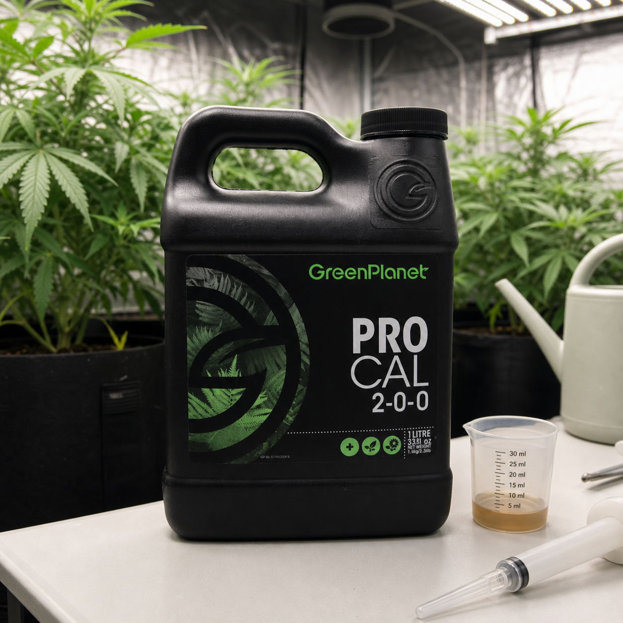 Garrafa negra Pro-Cal GreenPlanet sobre una mesa, junto a un vaso medidor y una jeringa, con plantas y una regadera al fondo. Garrafa negra Pro-Cal GreenPlanet sobre una mesa, junto a un vaso medidor y una jeringa, con plantas y una regadera al fondo.