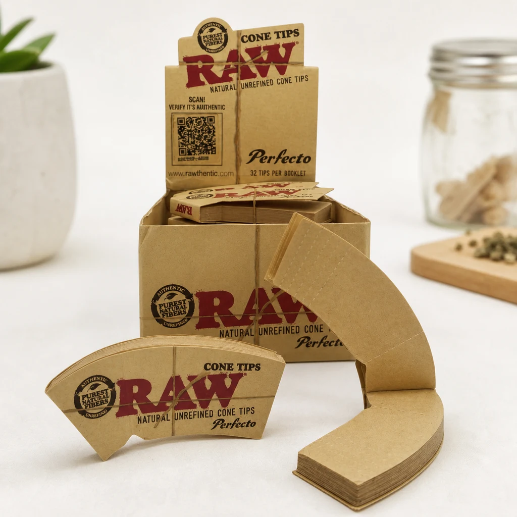 Expositor RAW Perfecto Cone Tips con libritos marrones y hojas curvas desplegadas en primer plano sobre una mesa blanca.