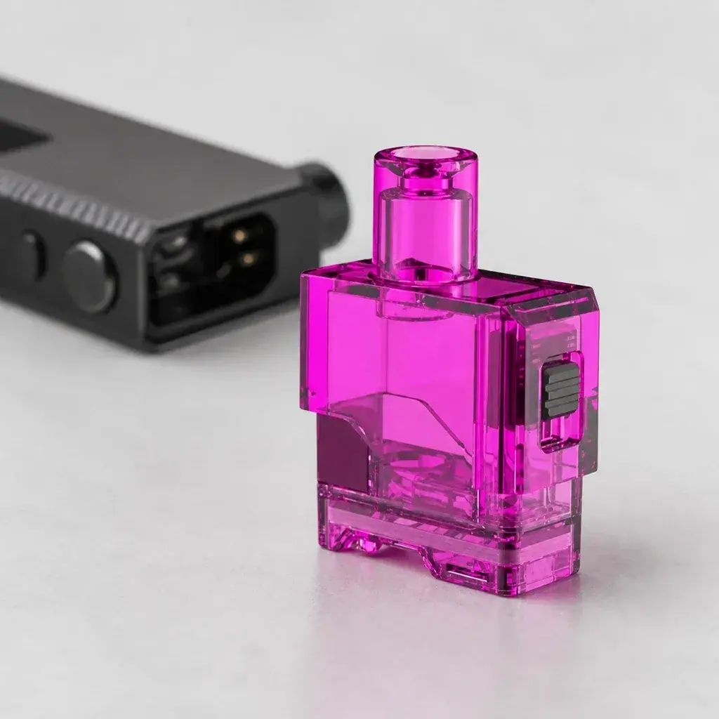 Cartucho Lost Vape Orion Art Pod rosa transparente, con boquilla cilíndrica y pieza lateral negra, junto a un dispositivo desenfocado.