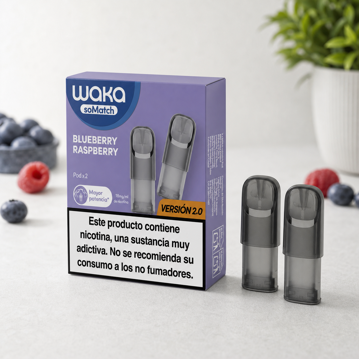 Pods Waka Blueberry Raspberry de boquilla oscura junto a su caja morada, con la inscripción «Versión 2.0», arándanos y frambuesas alrededor.