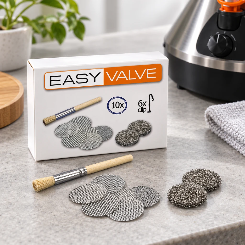 Caja Easy Valve junto a varias rejillas circulares, dos discos de malla gruesa y un cepillo, con un vaporizador parcialmente visible detrás.