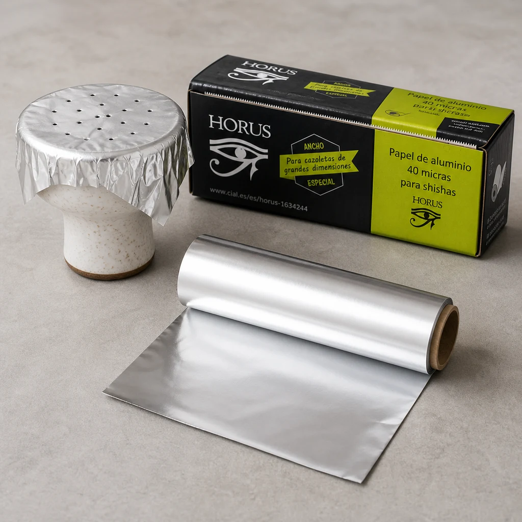 Rollo de papel de aluminio HORUS parcialmente desenrollado junto a su caja y una cazoleta cubierta con aluminio perforado.