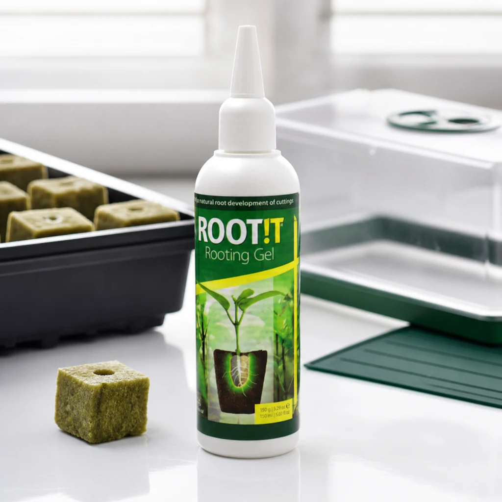 Botella blanca de gel ROOT!T con aplicador estrecho y etiqueta verde, junto a cubos de cultivo, una bandeja y un propagador con tapa transparente.