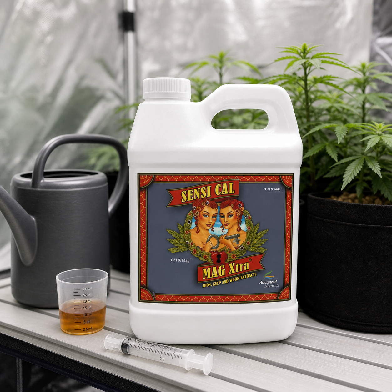 Garrafa de Sensi Cal-Mag Xtra junto a una regadera, un vaso dosificador y una jeringa, con plantas al fondo.