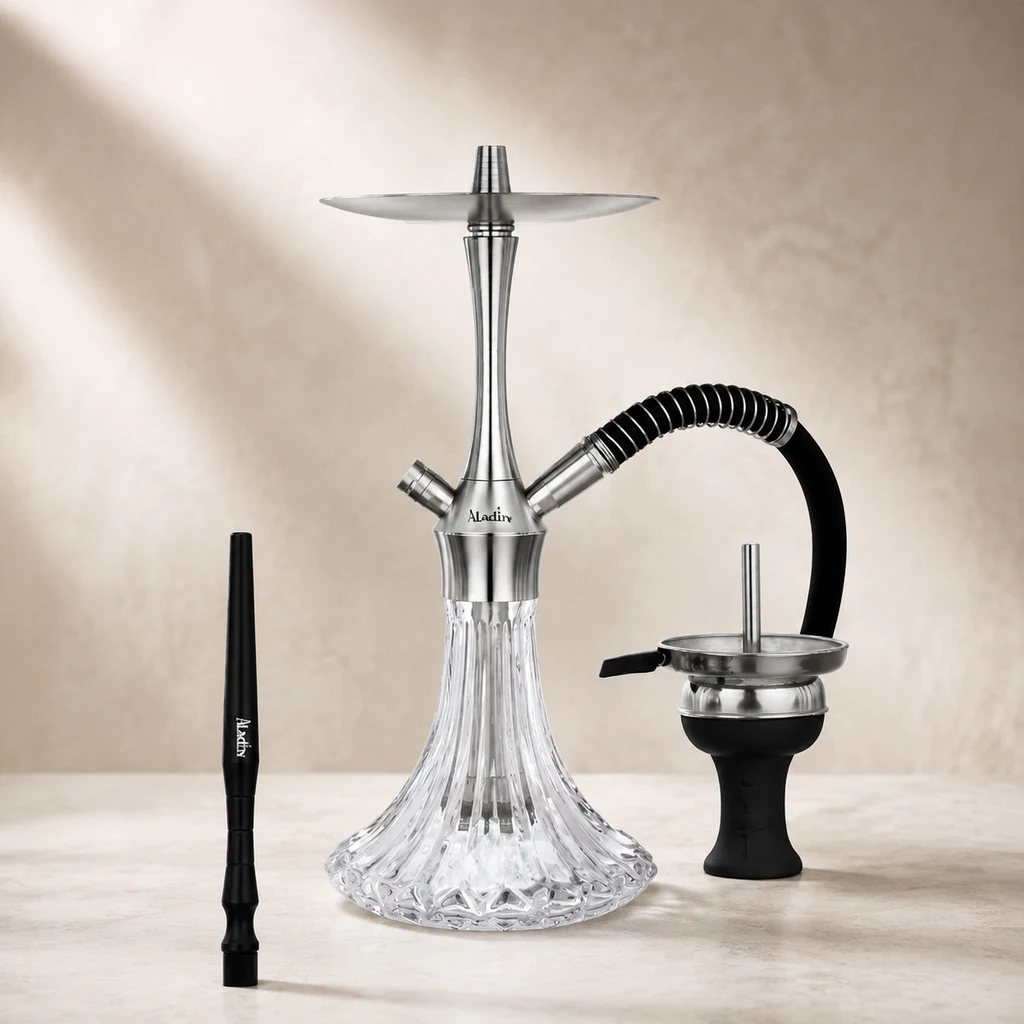 Cachimba Aladin MVP-A36 con base transparente tallada, cuerpo plateado y manguera negra; boquilla y cazoleta colocadas a los lados.
