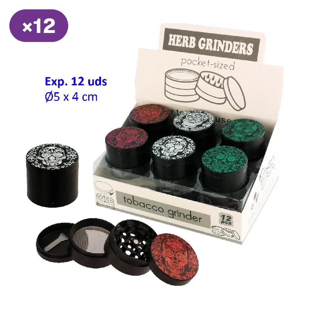 Grinders Skull negros con calaveras blancas, verdes y rojas en expositor, junto a un modelo desmontado que muestra dientes, tamiz y raspador.