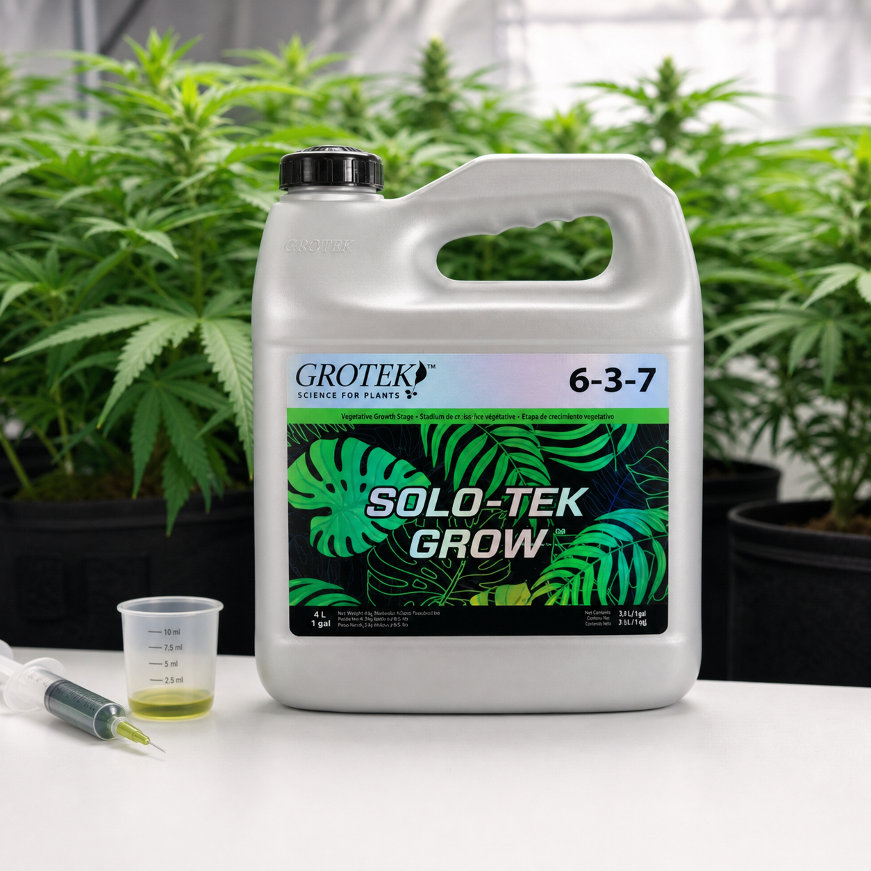 Garrafa de Solo-Tek Grow Grotek con asa, tapón negro y etiqueta 6-3-7, junto a un vaso medidor y una jeringa, con plantas al fondo. Garrafa de Solo-Tek Grow Grotek con asa, tapón negro y etiqueta 6-3-7, junto a un vaso medidor y una jeringa, con plantas al fondo.