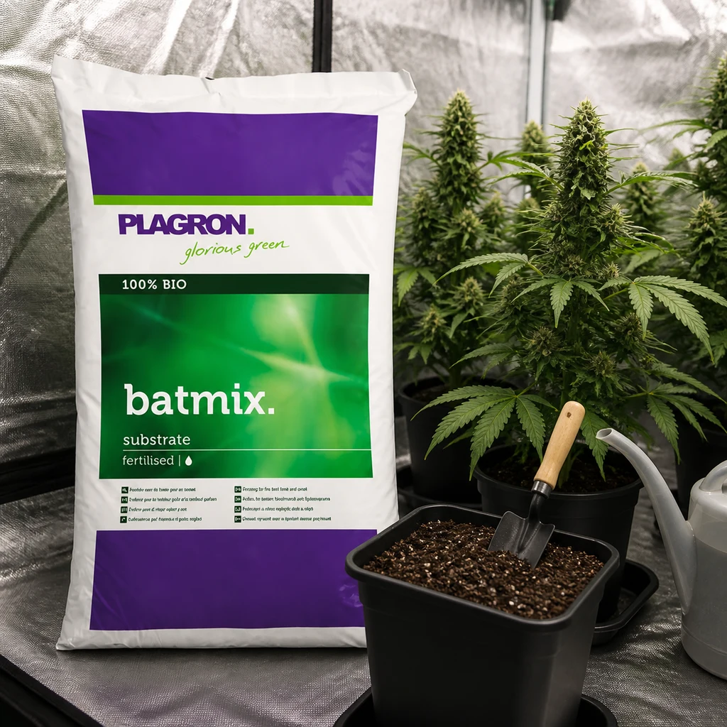 Saco de sustrato Batmix Plagron junto a una maceta con tierra y pala, una regadera y plantas en un recinto reflectante.