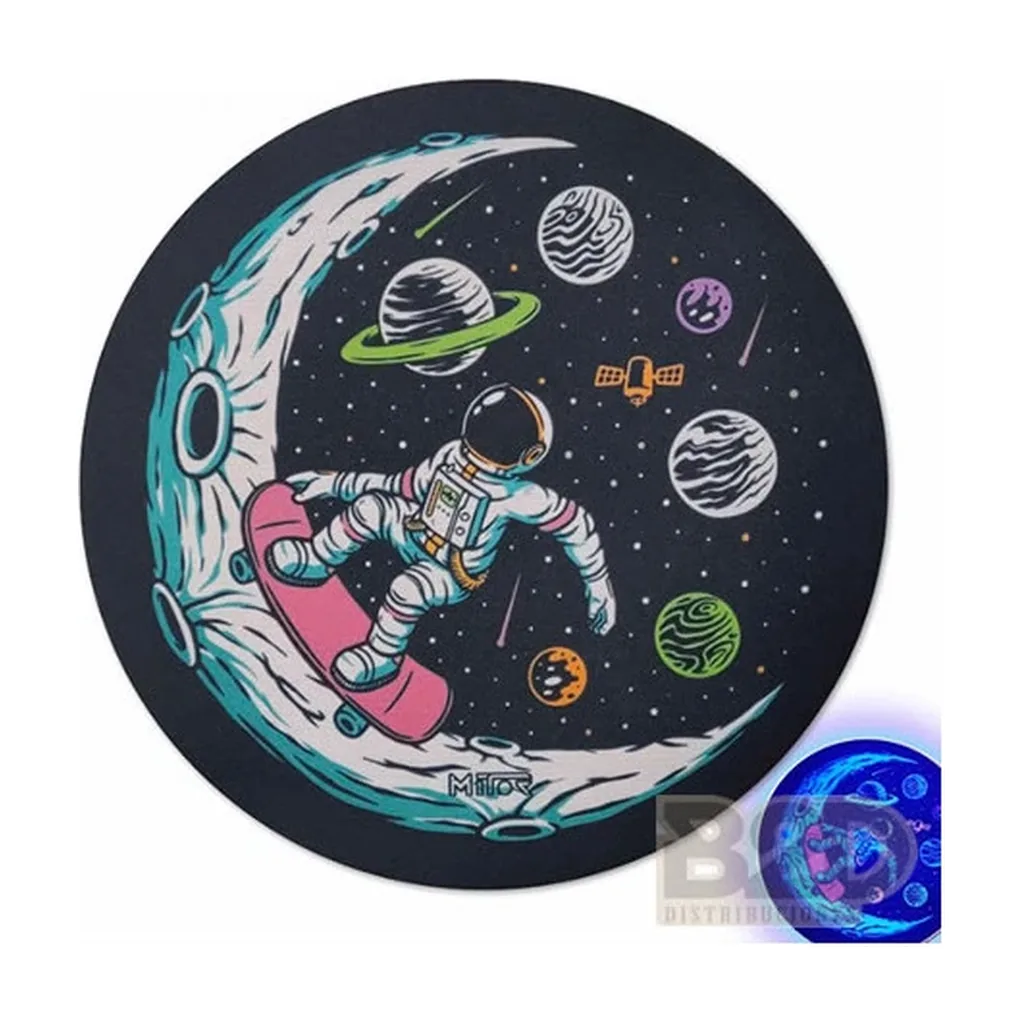 Tapete circular Mitor con un astronauta en monopatín sobre una luna y planetas alrededor; un recuadro muestra el diseño bajo luz azul.