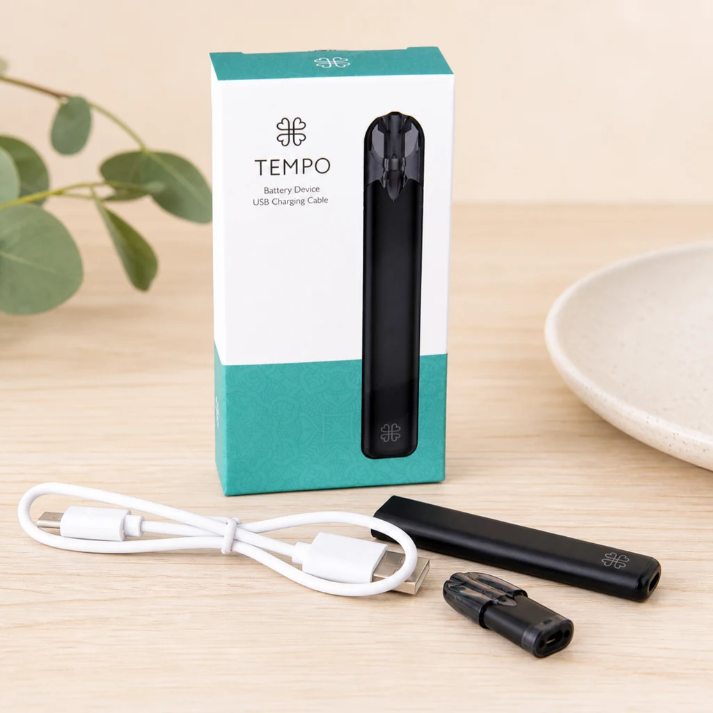 Tempo Pen Harmony negro junto a su caja blanca y turquesa, un cable USB blanco y un pod separado sobre una mesa clara.