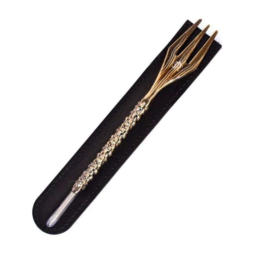 Tenedor punzón para cachimba de acabado dorado, con mango trenzado y punta plateada, colocado en diagonal sobre una funda negra.