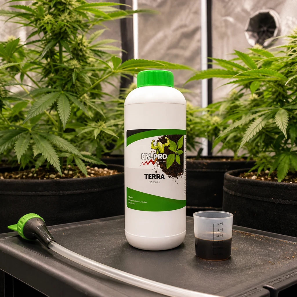 Botella de Terra HY-PRO con tapón verde junto a un vaso dosificador con líquido oscuro, sobre una bandeja y con plantas al fondo. Botella de Terra HY-PRO con tapón verde junto a un vaso dosificador con líquido oscuro, sobre una bandeja y con plantas al fondo.