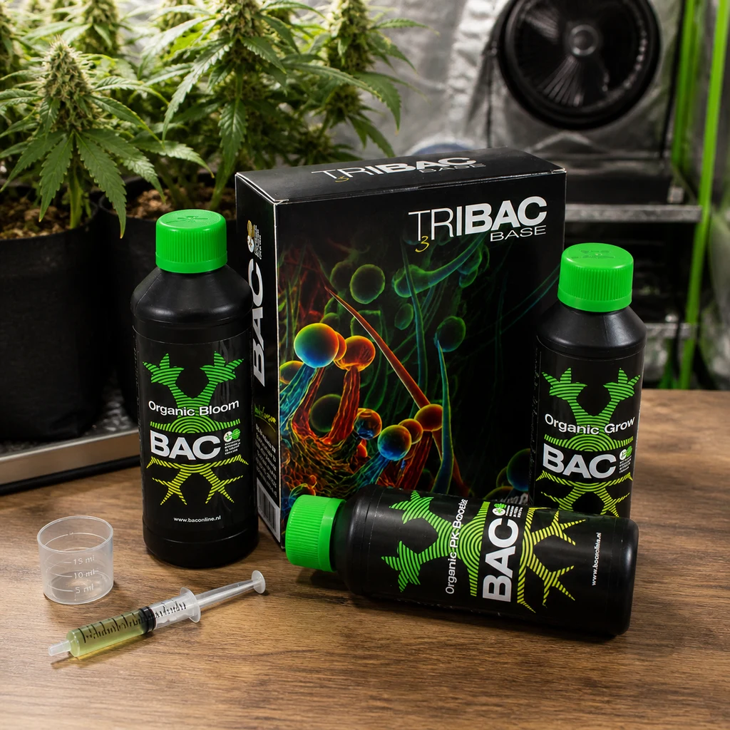Kit Tribac BAC con caja, botellas de tapón verde, vaso dosificador y jeringa sobre una mesa, con plantas y ventilador al fondo.