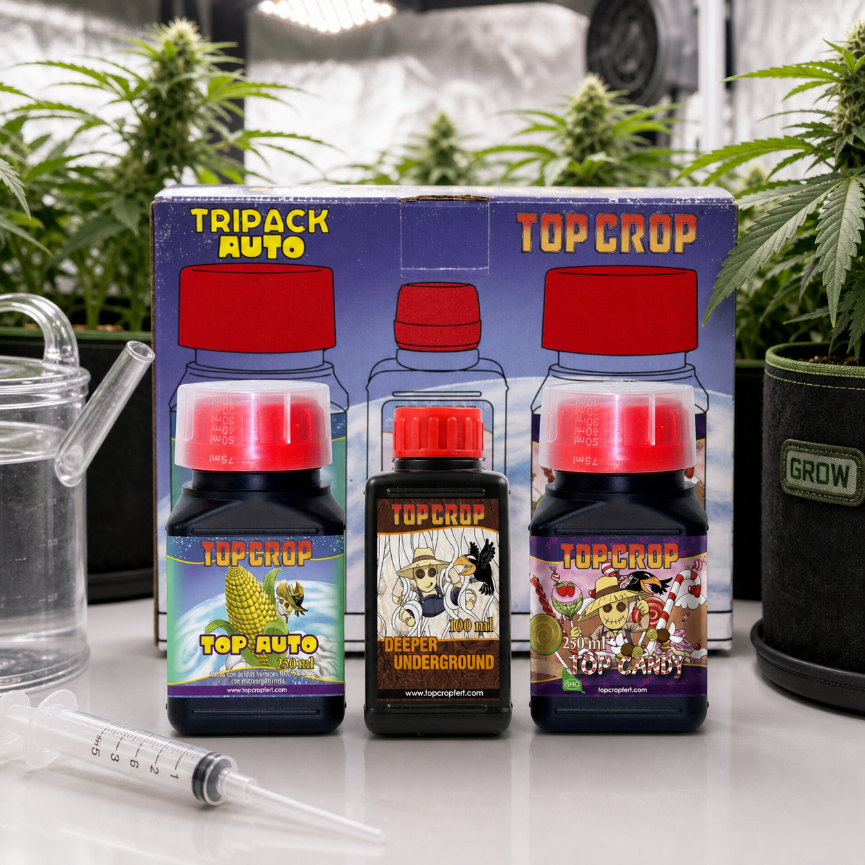 Tripack Auto de Top Crop con envases de Top Auto, Deeper Underground y Top Candy ante su caja, con plantas y útiles de riego alrededor.