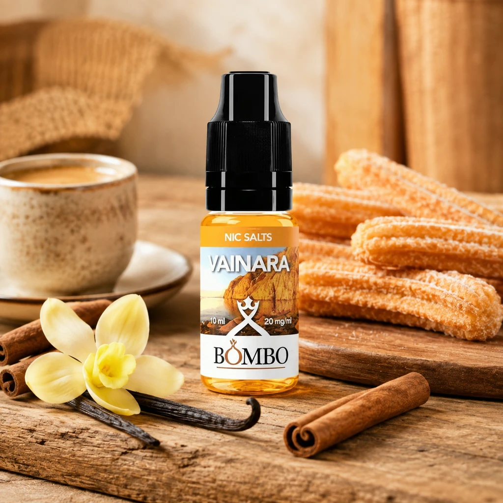 Frasco Vainara de Bombo con tapón negro y etiqueta de 10 ml y 20 mg/ml, junto a churros, una taza, vainilla y canela.