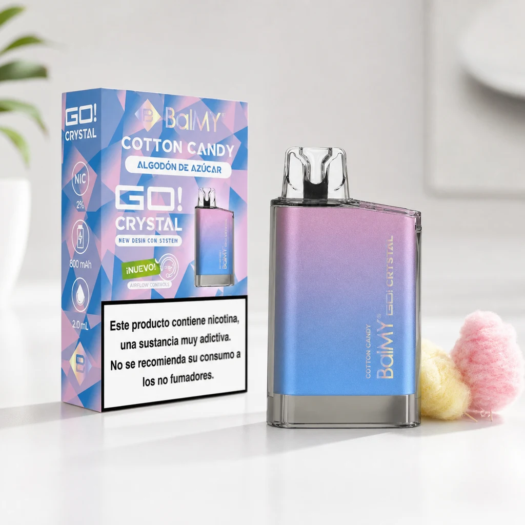 Vapeador BalMY GO Crystal Cotton Candy en degradado rosa y azul, junto a su caja y porciones de algodón de azúcar sobre una mesa blanca.
