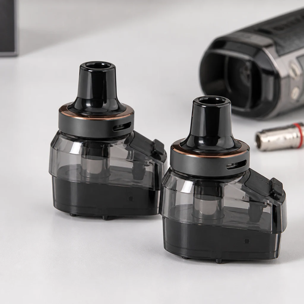 Pods Vaporesso Armour G de cuerpo translúcido oscuro y boquilla negra, con un dispositivo desenfocado al fondo. Pods Vaporesso Armour G de cuerpo translúcido oscuro y boquilla negra, con un dispositivo desenfocado al fondo.