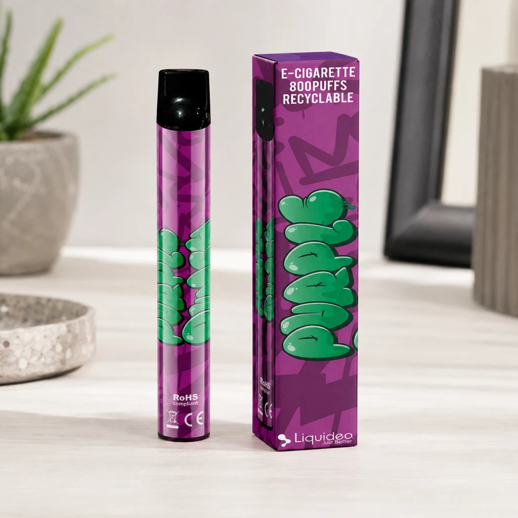 Escena generada de Wpuff Purple Punch de Liquideo: vaper morado con boquilla negra junto a su caja, sobre una mesa clara. Escena generada de Wpuff Purple Punch de Liquideo: vaper morado con boquilla negra junto a su caja, sobre una mesa clara.