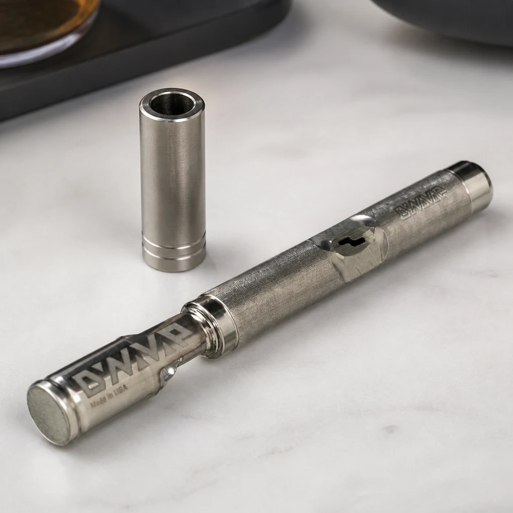 Escena generada del vaporizador Dynavap M7 metálico sobre una superficie clara, con el capuchón retirado colocado en vertical.