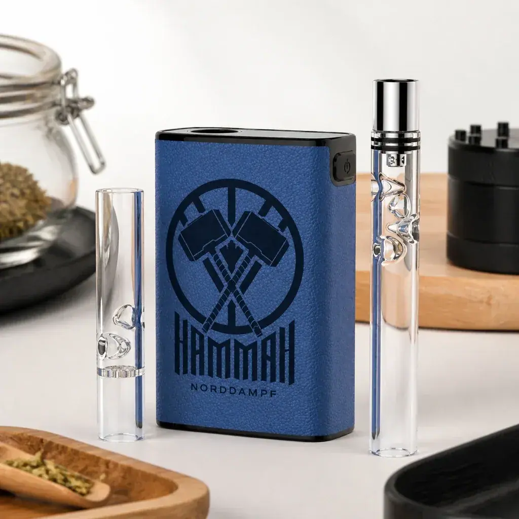 Vaporizador Hammah Norddampf azul con logotipo de martillos cruzados, entre accesorios transparentes de distinta longitud.
