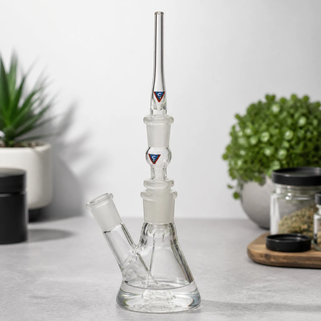 Vaporizador VapoCane Fusion de vidrio transparente montado sobre una base cónica, con tubo vertical largo y conexión lateral inclinada.