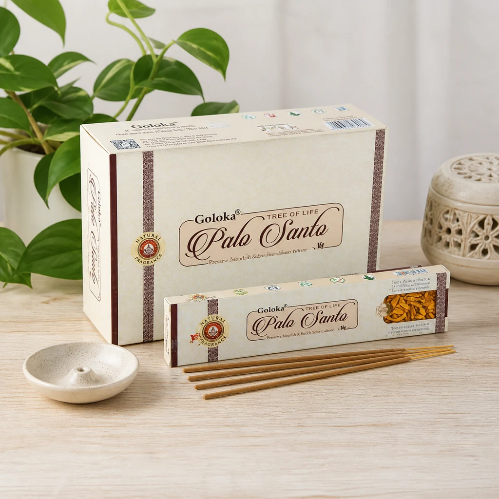 Varillas de incienso Goloka Palo Santo junto a sus cajas y un pequeño soporte sobre una mesa, con una planta al fondo.
