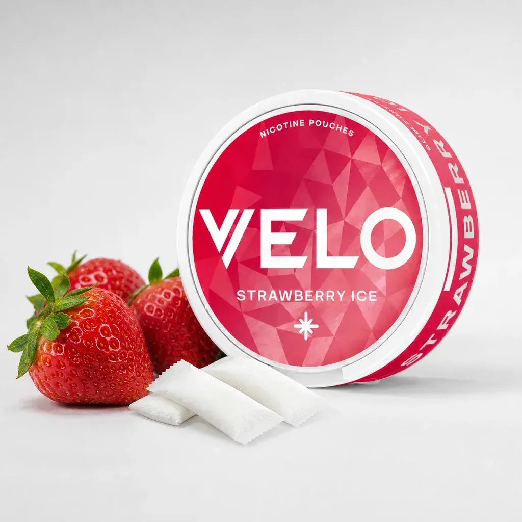 Envase redondo de VELO Fresa Hielo con etiqueta roja «Strawberry Ice», junto a fresas y varias bolsitas blancas.