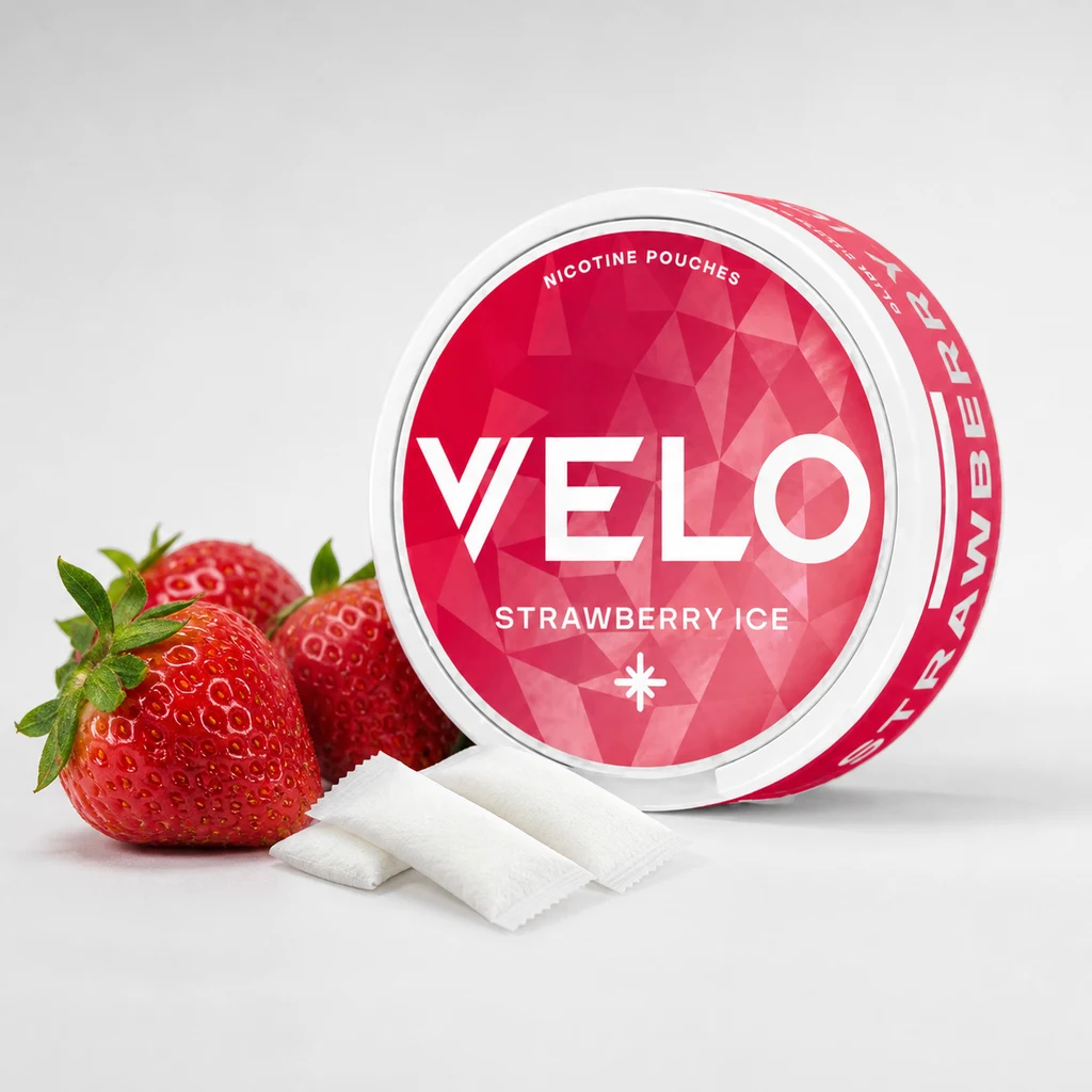 Envase redondo de VELO Fresa Hielo con etiqueta roja «Strawberry Ice», junto a fresas y varias bolsitas blancas.