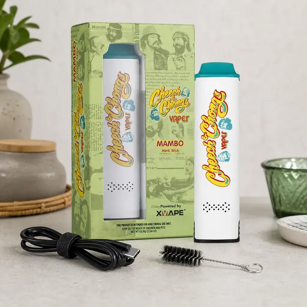 Vaporizador X-Vape Cheech and Chong blanco con boquilla turquesa, junto a su caja verde, cable y cepillo de limpieza.